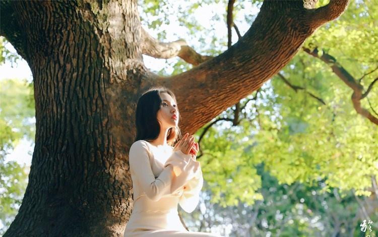 大树下清纯灵动美女手捧苹果纤细身形图片